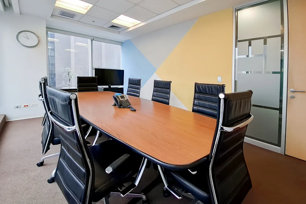 Sala de reuniones de Apaza Abogados con mesa de madera y sillas de cuero